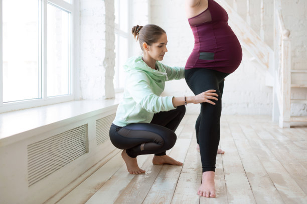 私人瑜伽教练与孕妇工作图片下载