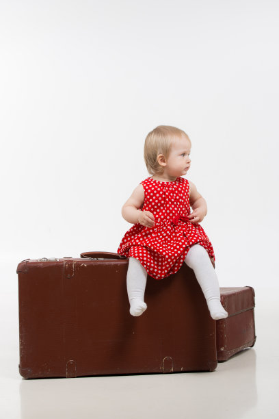 可爱的小女孩坐在行李箱上图片下载