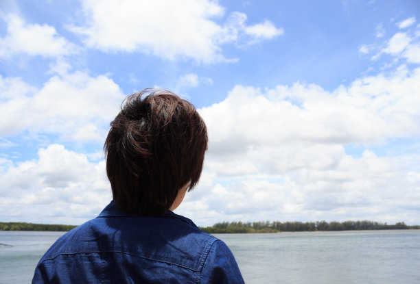年轻人的背影望着大海，思考着大海图片下载