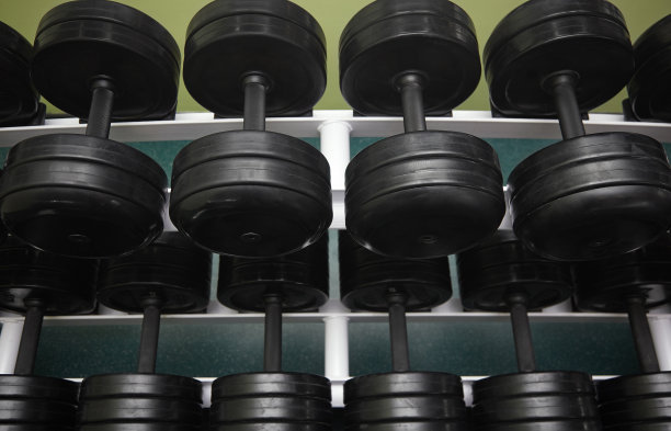 一组黑色杠铃在体育馆排成一排图片下载