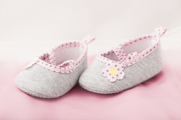 粉色和灰色的婴儿鞋在粉红色的背景图片下载