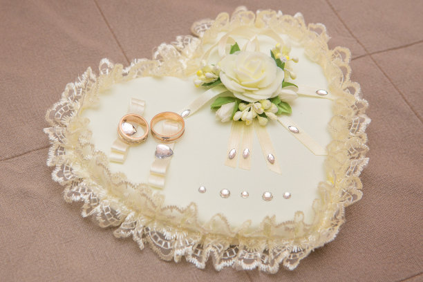 结婚戒指躺在白色的垫子上图片下载