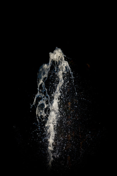 清澈的水在黑色的背景前涌出图片下载