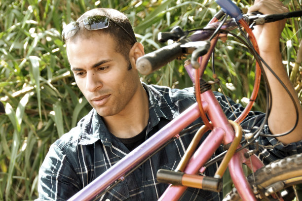 混血儿在修理一辆旧自行车图片下载