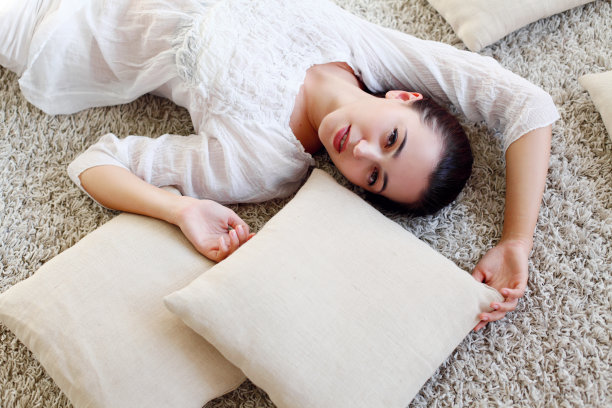 女孩抱着枕头躺在地板上图片下载
