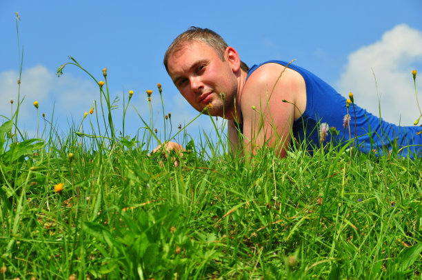 年轻人仰天躺在草地上图片下载