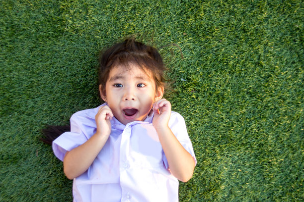 亚洲泰国的孩子在绿色的草地上微笑图片下载