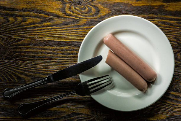用盘子和叉子煮香肠。图片下载