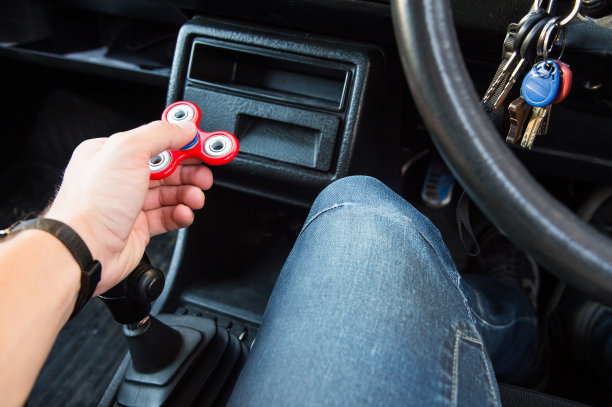 一个男人的手玩一个转盘的特写，而在一个交通堵塞的背景汽车的内部图片下载