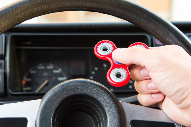 一个男人的手玩一个转盘的特写，而在一个交通堵塞的背景汽车的内部图片下载