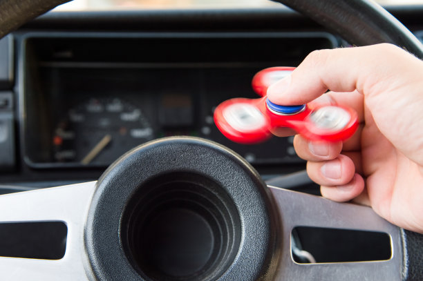 一个男人的手玩一个转盘的特写，而在一个交通堵塞的背景汽车的内部图片下载