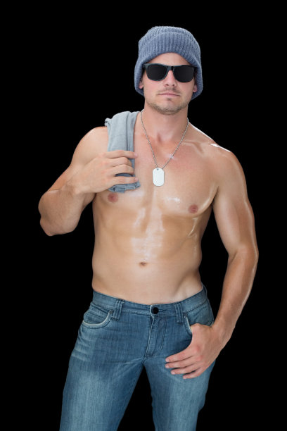 肌肉男摆姿势在蓝色牛仔裤帽子和太阳镜图片下载