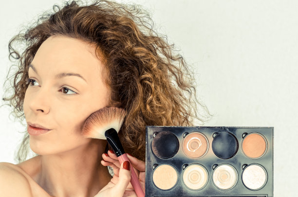 美丽的青少年教化妆和应用脸部轮廓图片下载