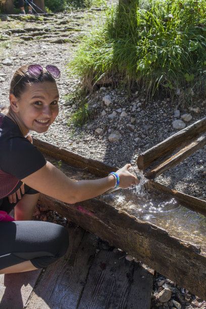 年轻漂亮的女人从山涧里取水图片下载