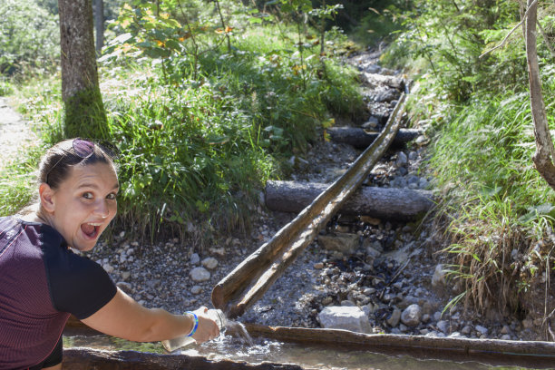 年轻漂亮的女人从山涧里取水图片下载