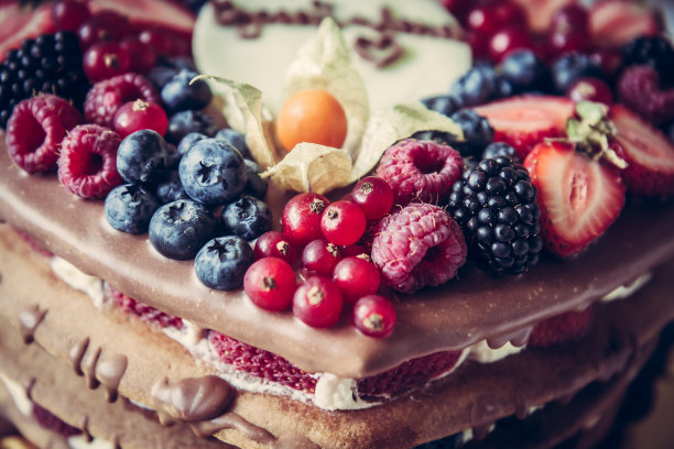 为庆祝活动，在蛋糕上面铺上混合浆果图片下载