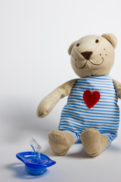 奶瓶、奶嘴和玩具躺在白色的背景上。图片下载