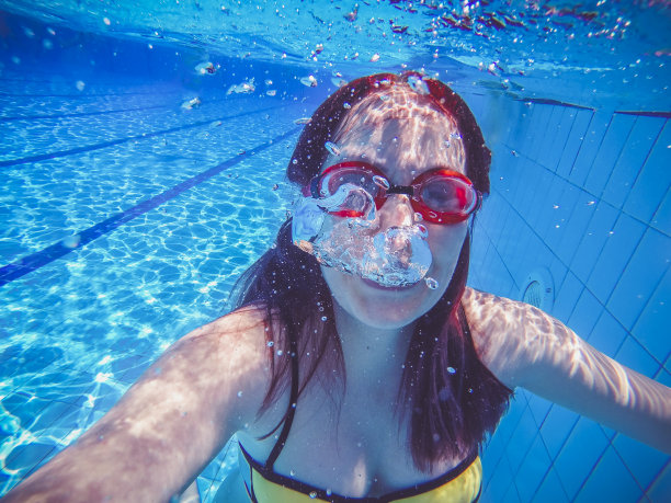 女游泳运动员在水池中从水里涌出图片下载