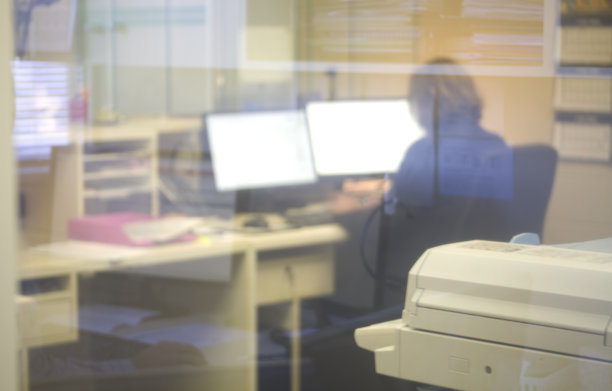 一个女人透过办公室窗户在工作图片下载