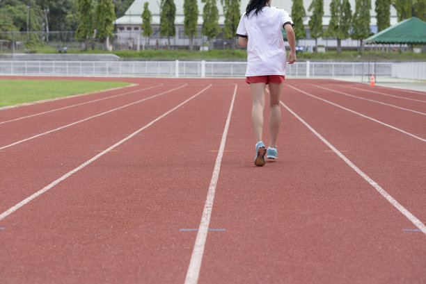 年轻女子在训练期间在跑道上跑步。亚洲图片下载