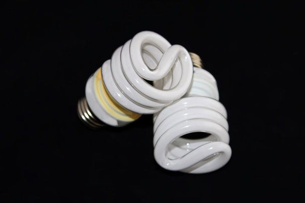 两个荧光灯泡的特写孤立在一个黑色的背景图片下载