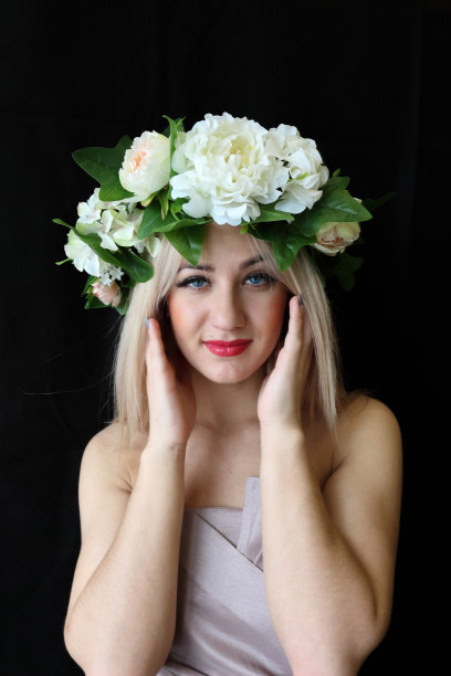 美丽年轻的金发女人穿着黑色的衣服，戴着花圈图片下载