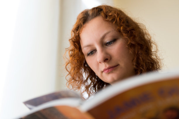 橙色卷发的女人在看书图片下载