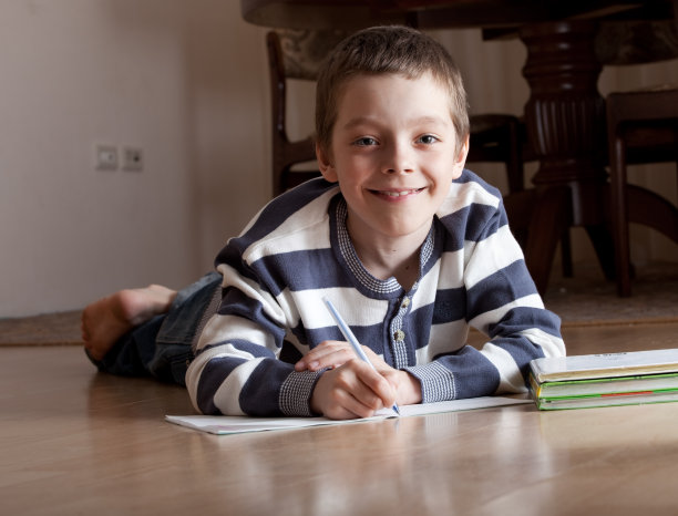 男孩躺在地板上上课图片下载