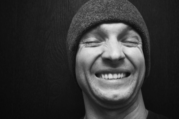 戴着灰色帽子笑着的年轻人图片下载