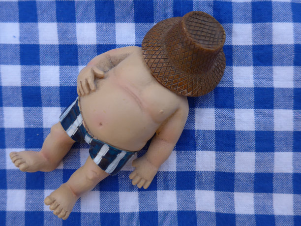 胖子躺在一条蓝格子的毛巾上图片下载