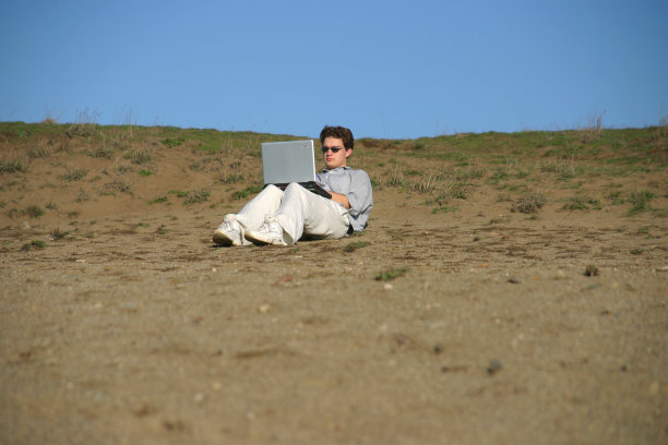 沙滩上拿着笔记本电脑的人图片下载