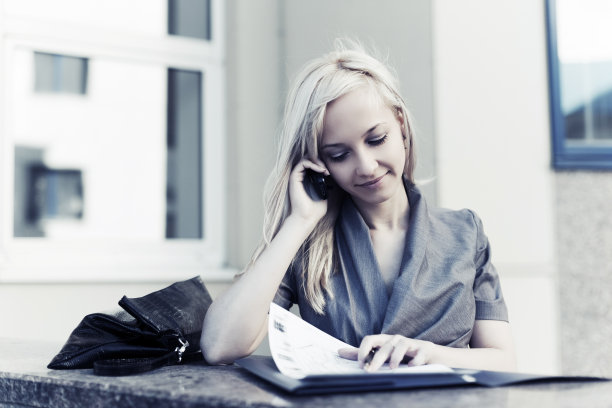 年轻的女商人拿着文件夹打电话图片下载