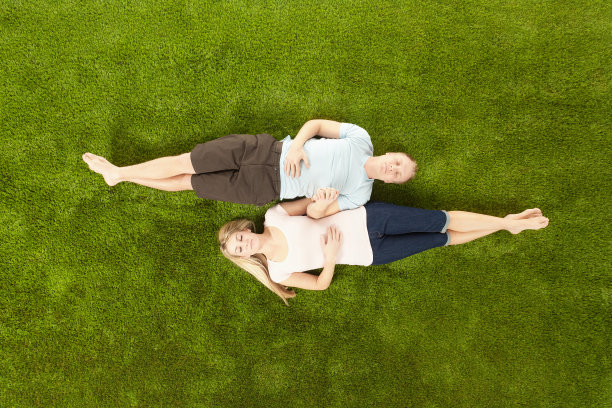 一对情侣躺在草地上图片下载