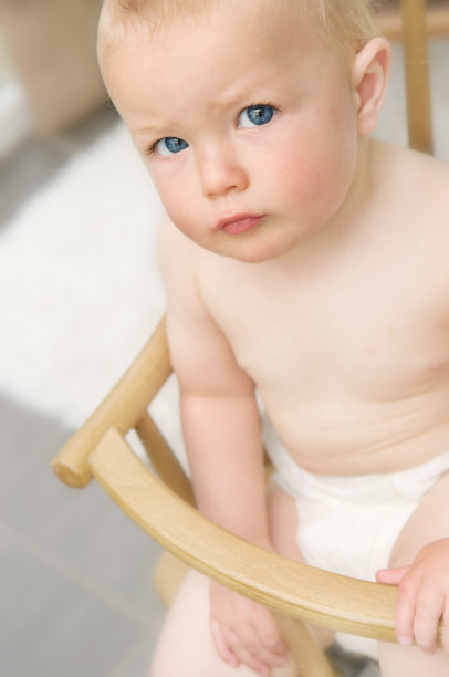 小男孩好奇地从他的高椅子上抬起头来图片下载