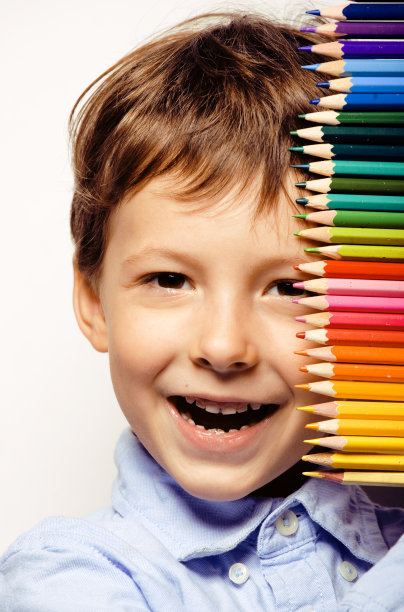 可爱的小男孩拿着彩色铅笔近距离微笑图片下载