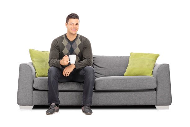 拿着一杯咖啡的男人坐在沙发上图片下载