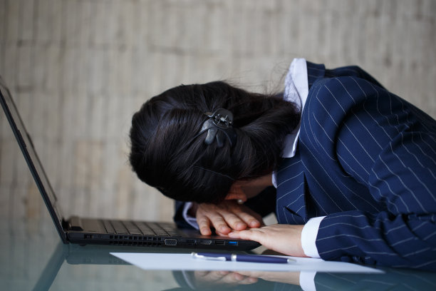 疲惫的女商人睡在笔记本电脑上图片下载