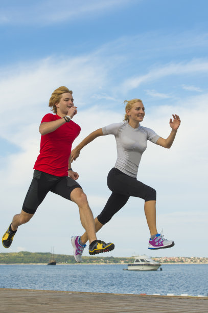 一对年轻夫妇在海边慢跑图片下载