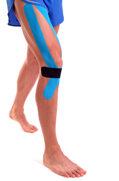 膝盖上的运动机能学胶带。物理治疗的运动员图片下载