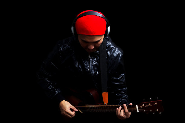 低调肖像照片的亚洲吉他手演奏吉他图片下载