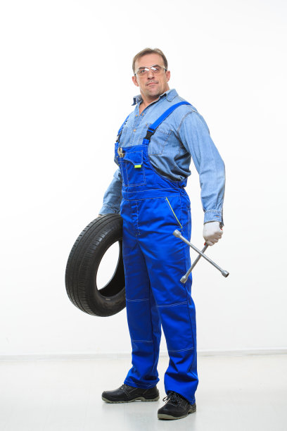 成年男性技工，带着扳手和轮胎图片下载