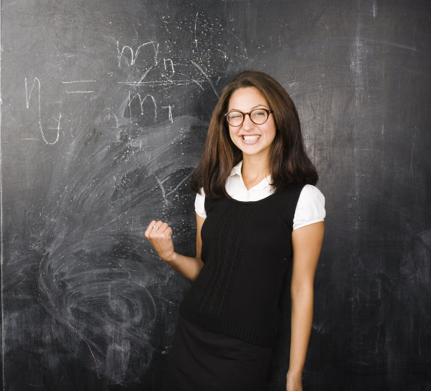 快乐可爱的学生在教室的黑板上微笑的肖像图片下载