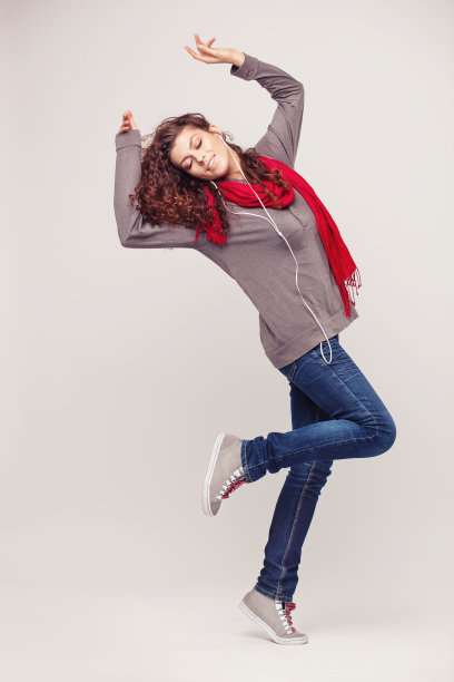 带着耳机在灯光背景下跳舞的女孩图片下载