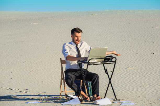 商人在沙漠中使用笔记本电脑图片下载