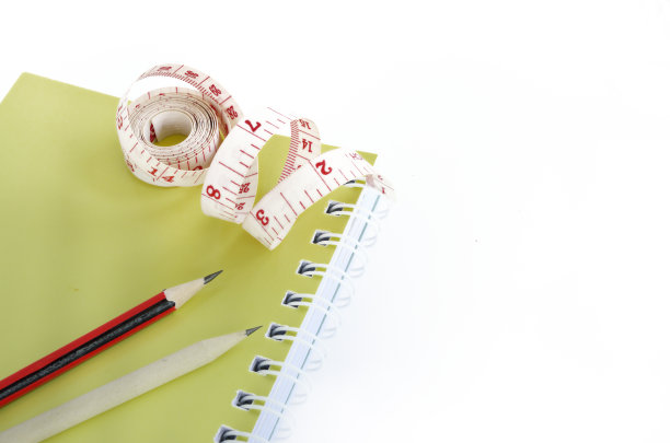 书本和铅笔用卷尺测量白色图片下载