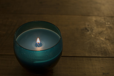 木制桌子上的蓝色玻璃蜡烛图片下载