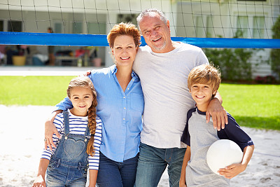 爷爷奶奶和孙子孙女在花园里打排球图片下载