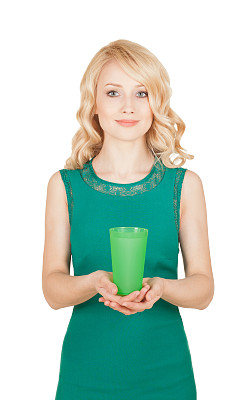 漂亮的金发女郎拿着一只绿色的玻璃杯图片下载
