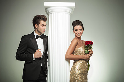 优雅的男人穿着燕尾服看着他笑着的女人图片下载