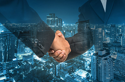 城市景观上的商人之间的双重曝光握手图片下载